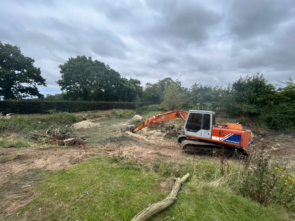 Excavator clearing land in rural field