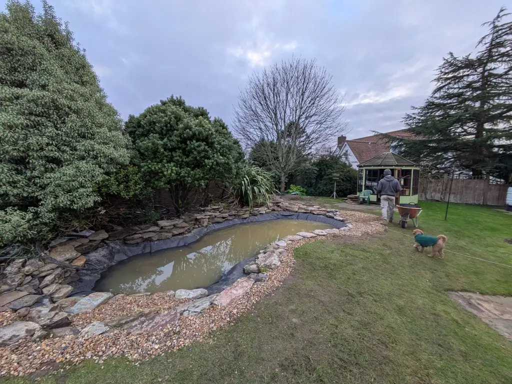 Garden pond with man, dog and gazebo
